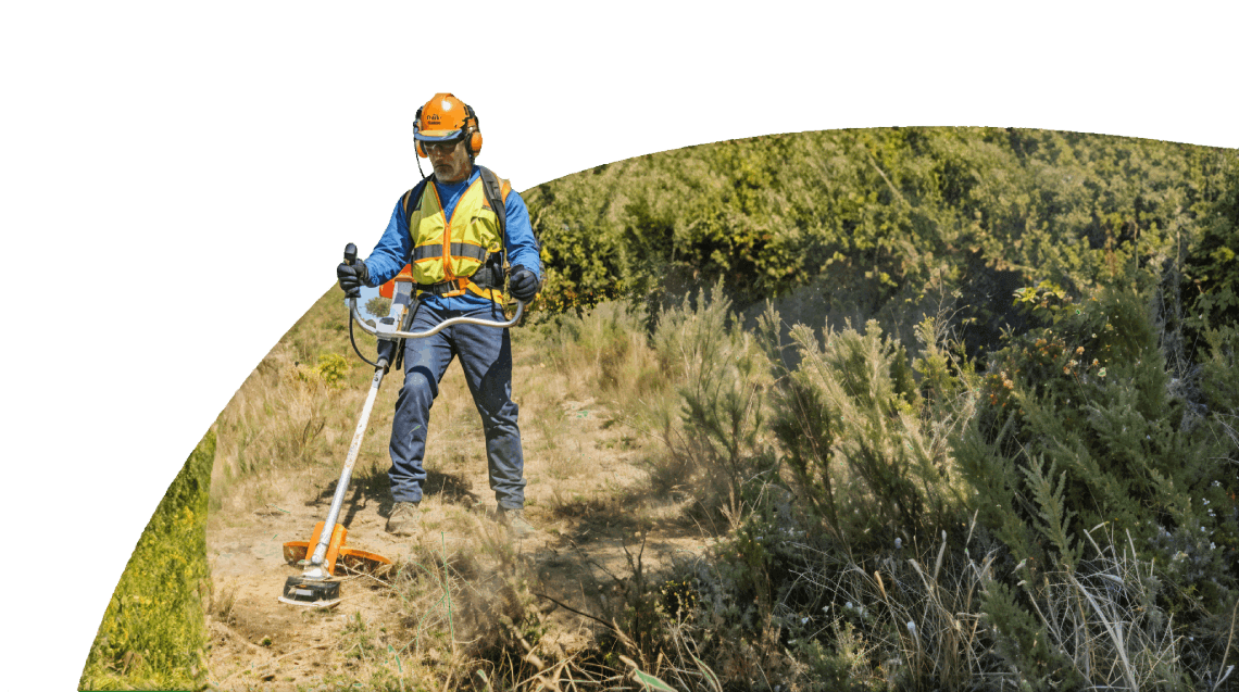 Worker using weed whacker